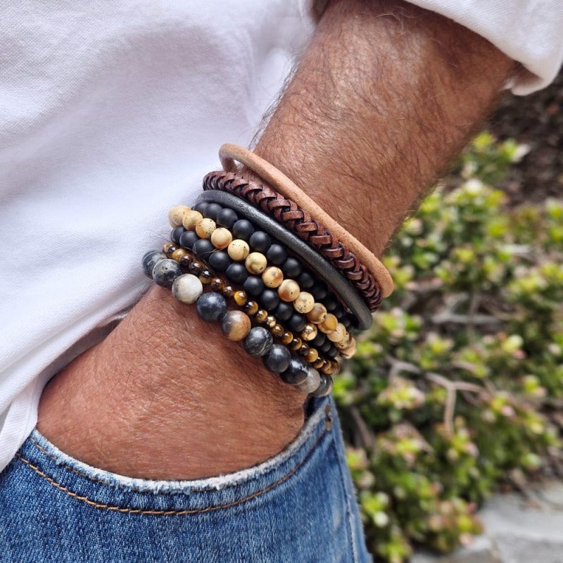 2 men s black onyx beaded bracelets stacked w 2 tiger s eye beaded bracelets w 14k gold beads w agate bead bracelet and 3 thick men s leather bracelets white shirt