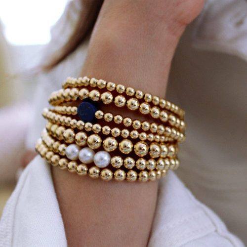 3mm 5mm and 6mm 14k gold filled bracelets with pearl and lapis beads stacked w white shirt