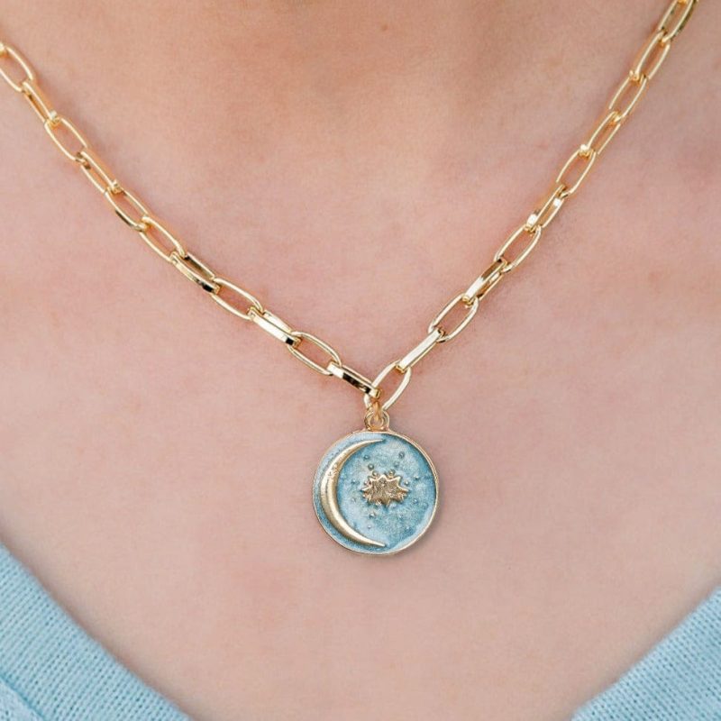 Kinsley gold chain necklace with blue moon celestial pendant blue sweater