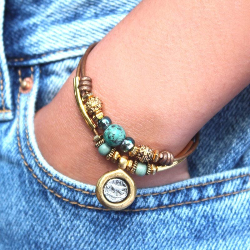 moss gold and turquoise bracelet with silver gold coin charm denim pants