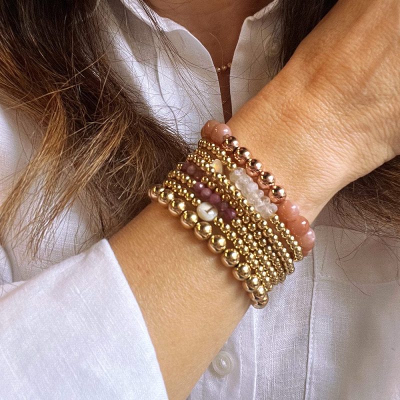 pink sandstone and 14k gold bracelet stack with amethyst pearls and initial charm white shirt