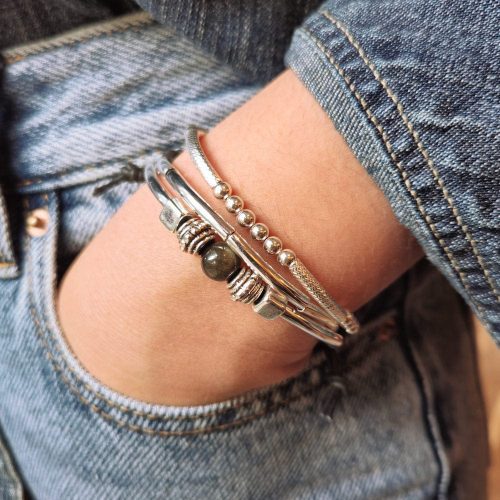 sofi silver and leather bracelet w golden obsidian next to Lim sterling silver bead stretch bracelet denim