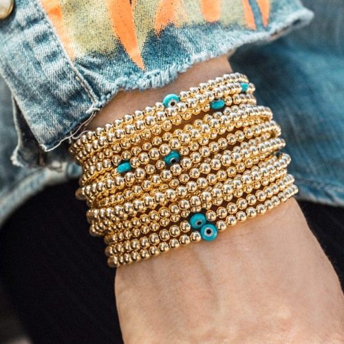 stacked 14k gold filled bracelets with evil eye charms denim