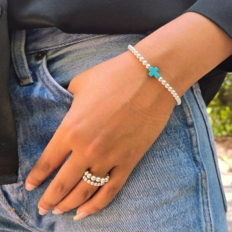 sterling silver stretch bracelet w turquoise cross charm and 2 sterling silver bead rings denim black